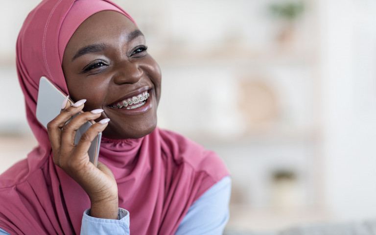 moslim vrouw met glimlach en smartphone