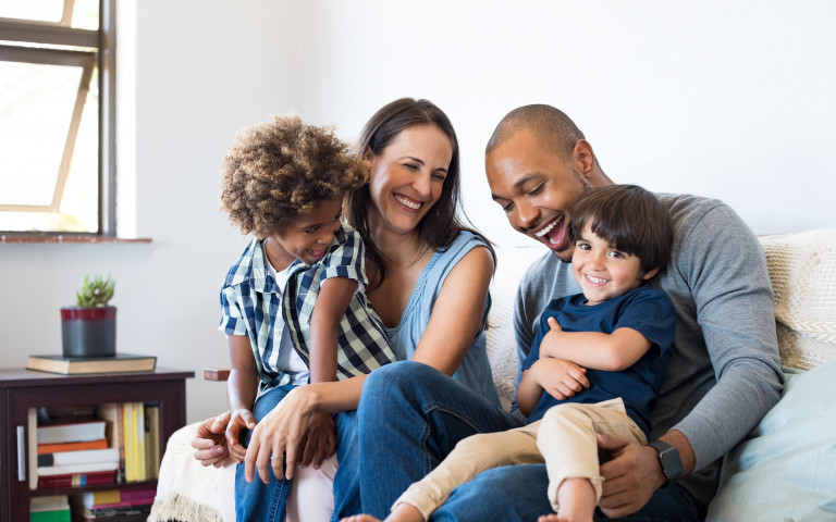 Parents et fils souriants assis sur canapé