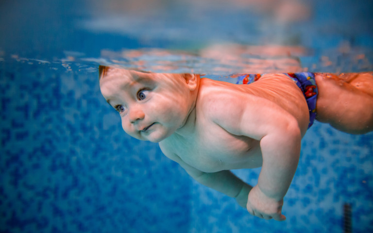 baby die zwemt in een zwembad