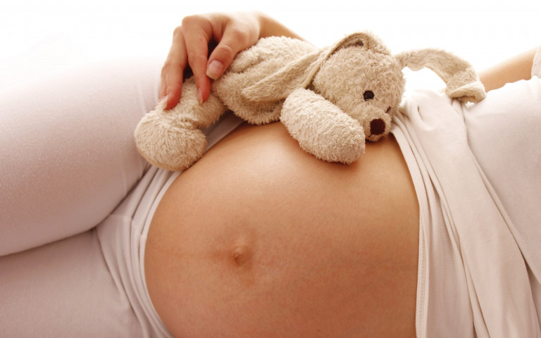 peluche sur le ventre d'une femme enceinte