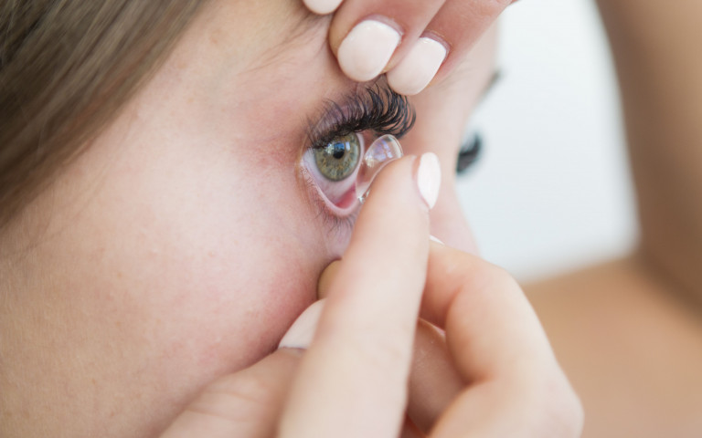 Femmes qui met une lentille de contact