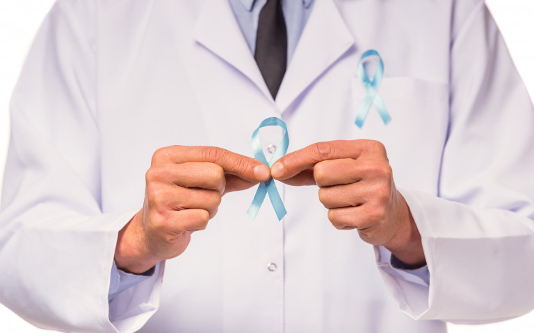 Dokter met blauw lintembleem tegen prostaatkanker in de hand