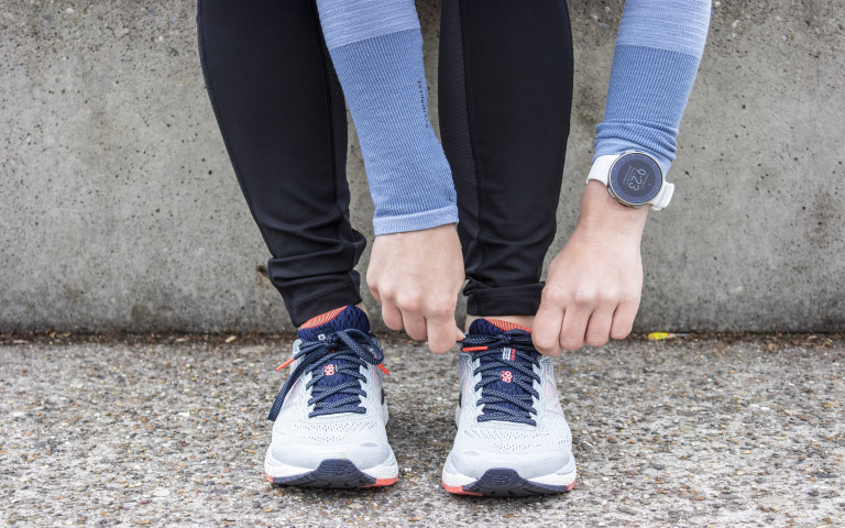 une femme chausse ses chaussures pour aller faire du sport