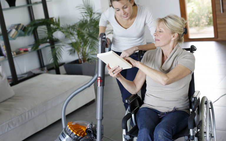 Aide à la maison avec une dame en fauteuil roulant