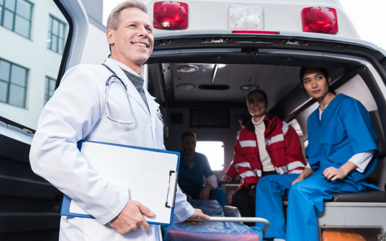 équipe de soignants dans une ambulance avec médecin à l'avant plan