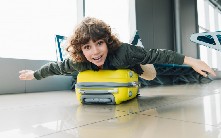 jongen op valies in luchthaven
