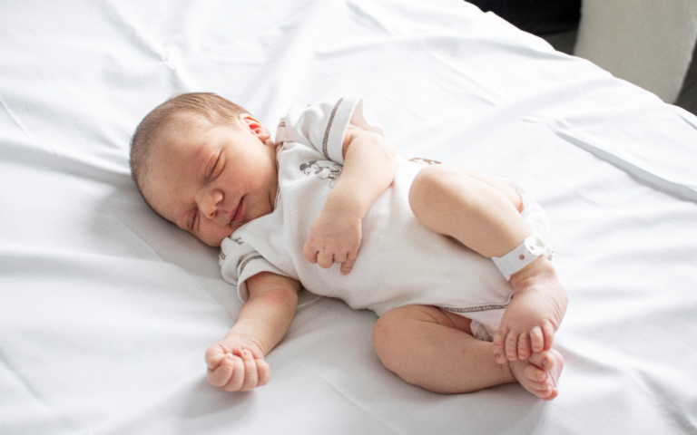 Pasgeboren baby op bed.