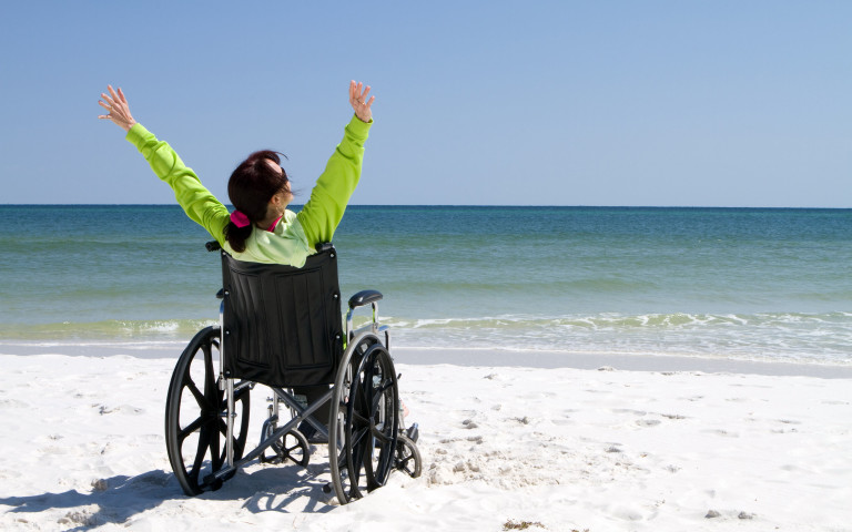 vrouw in rolstoel op strand