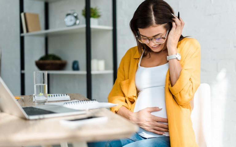 zwangere vrouw werkt op laptop