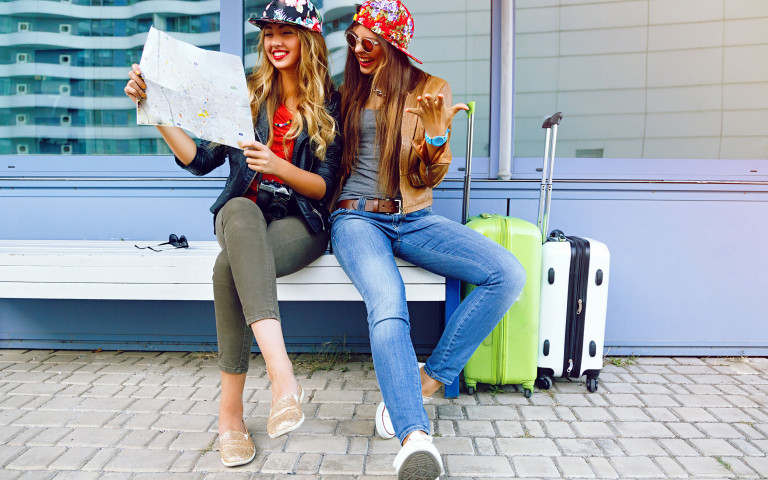 deux femmes avec leurs valises qui sont heureuses d'être en citytrip