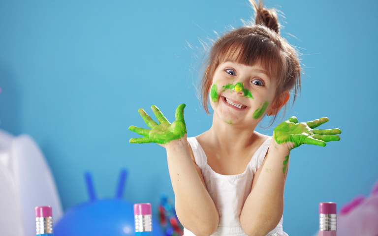 Petite fille recouverte de peinture pendant une activité