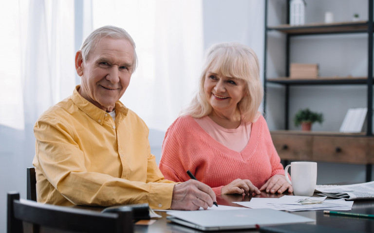 Oudere man en vrouw tekenen documenten