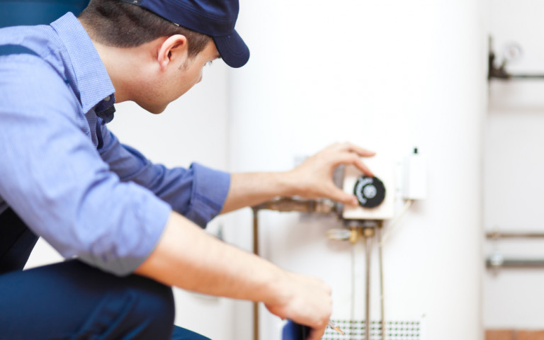 Technicien avec casquette répare boiler