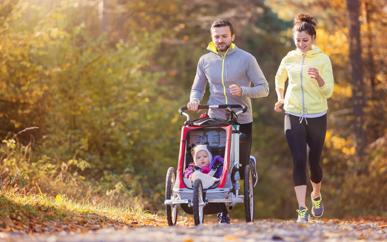 Ouders joggen met kinderwagen