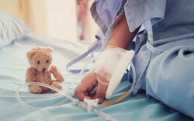 Ziek kind in ziekenhuis met teddybeer 