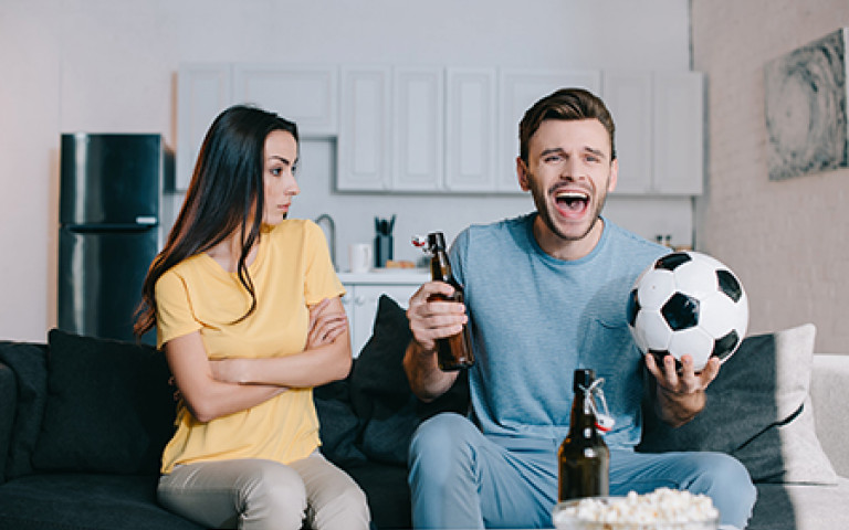 Un couple regarde un match de football à la télévision