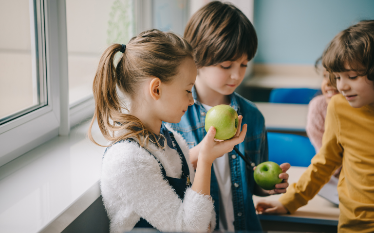 Kinderen eten groene appels op school