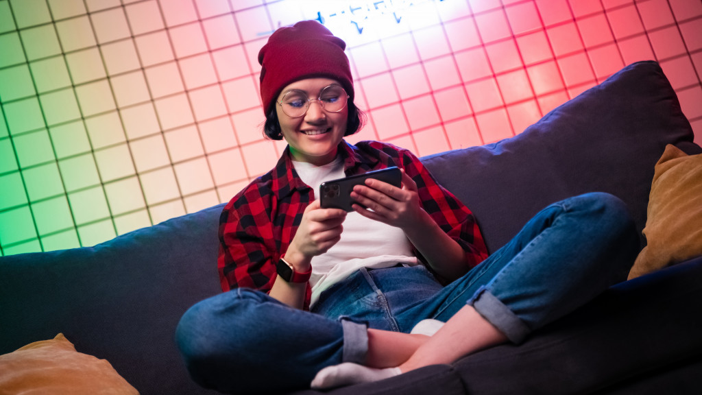 Tiener speelt game op smartphone in zetel