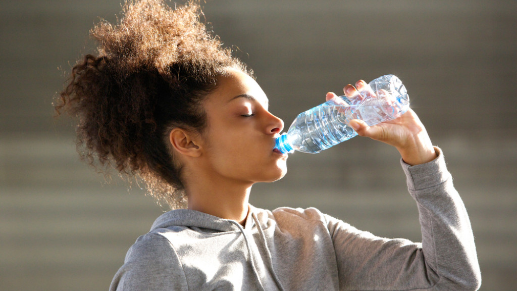 Fille boit de l'eau après l'exercice