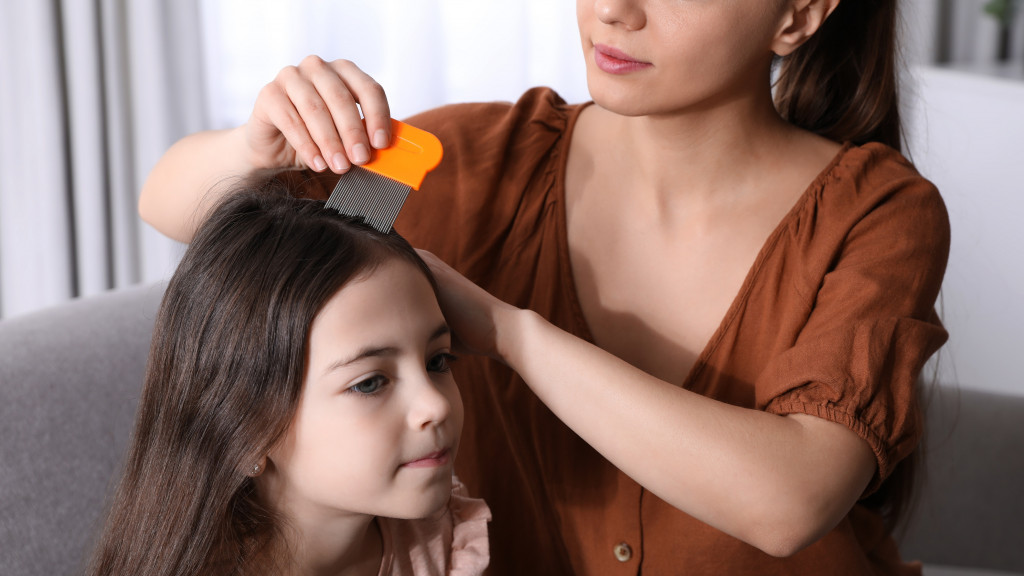 femme cherche des poux dans les cheveux d'un enfant