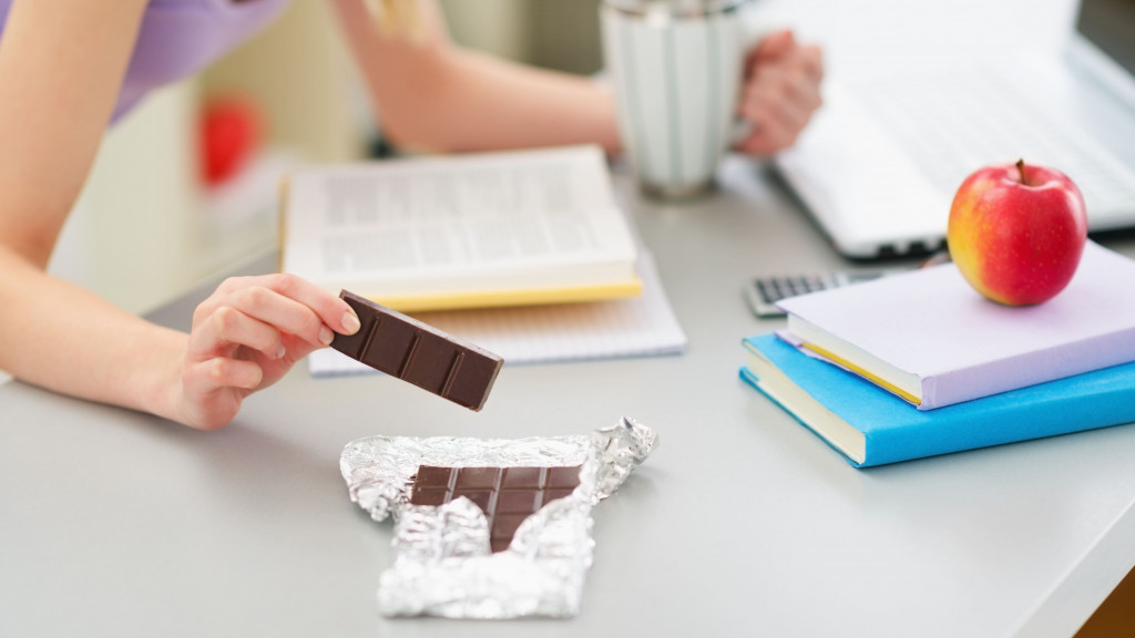 meisje dat chocolade eet tijdens het studeren