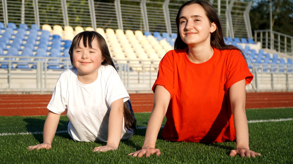 Meisje met beperking en coach sporten op een grasplein