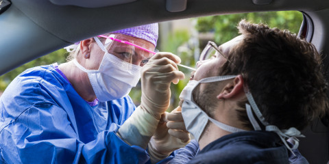 une infirmière fait un test coronavirus à un homme dans sa voiture
