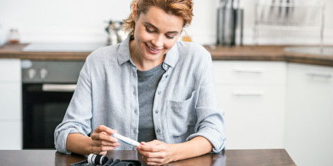 Vrouw met diabetes prikt waarden in keuken