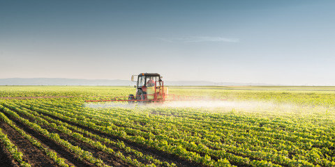 Landbouwer sproeit veld met tractor