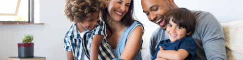 Parents et fils souriants assis sur canapé