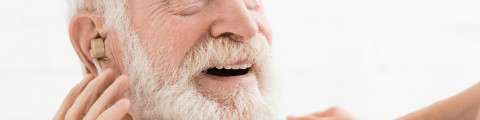 Homme âgé portant un appareil auditif à l'oreille