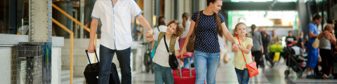 famille dans une gare prête à partir en vacances