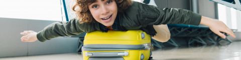 jongen op valies in luchthaven