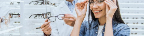 Opticien et une cliente qui essaye des lunettes