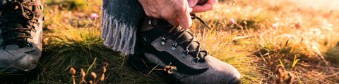 Homme fait ses lacets de chaussures de marche