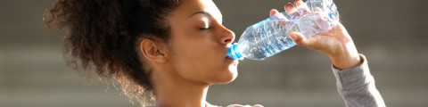 Fille boit de l'eau après l'exercice