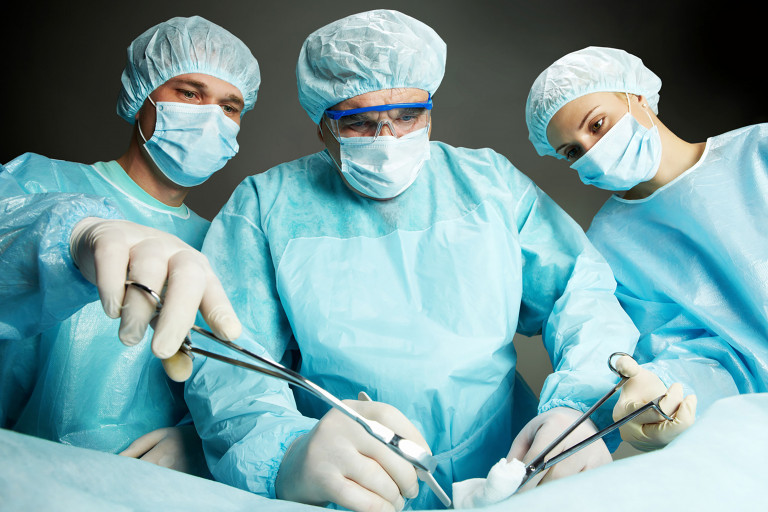 Trois chirurgiens pratiquant une opération sur fond noir