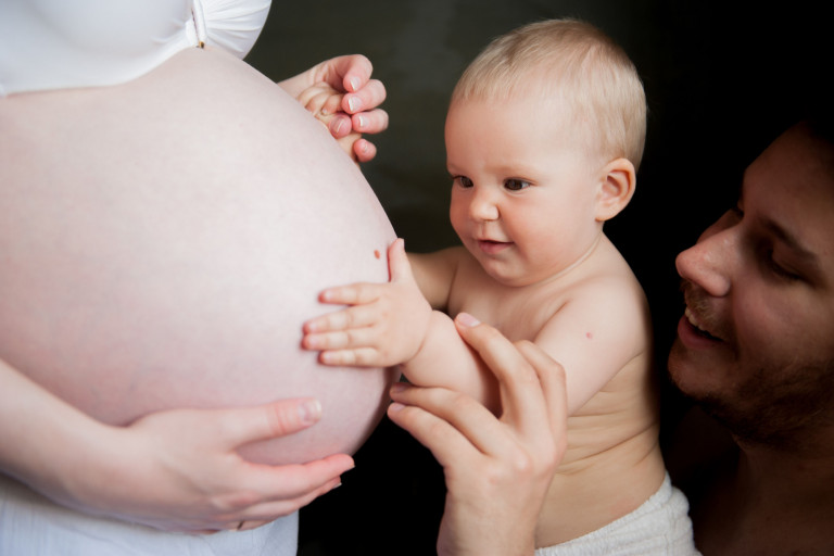 Baby en vader voelen aan zwangere buik