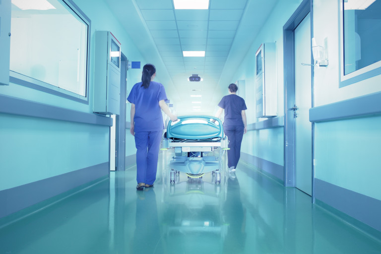 Infirmières qui poussent un lit dans un couloir d'hôpital