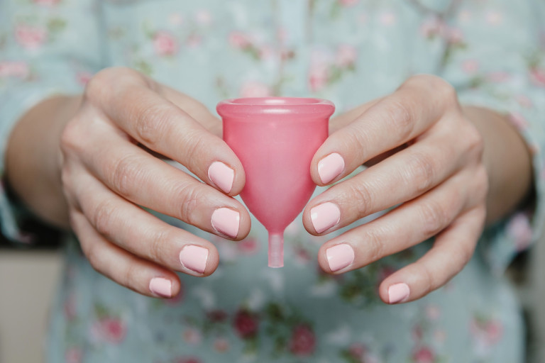 Vrouw houdt menstruatiecup tussen haar handen