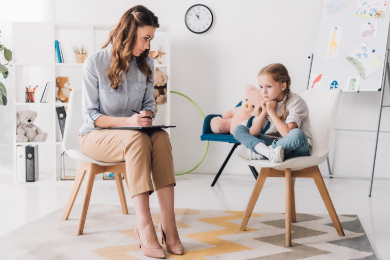 Kinderpsycholoog praat met jong meisje tijdens therapie