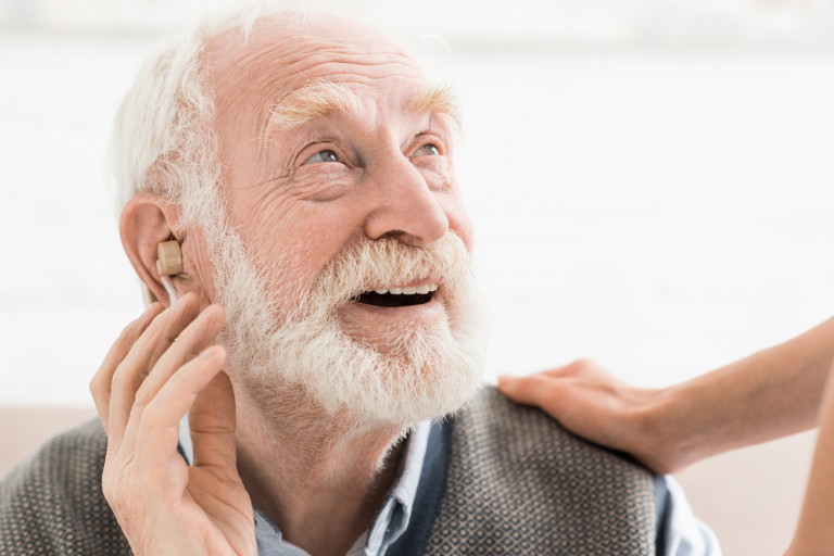 Homme âgé portant un appareil auditif à l'oreille