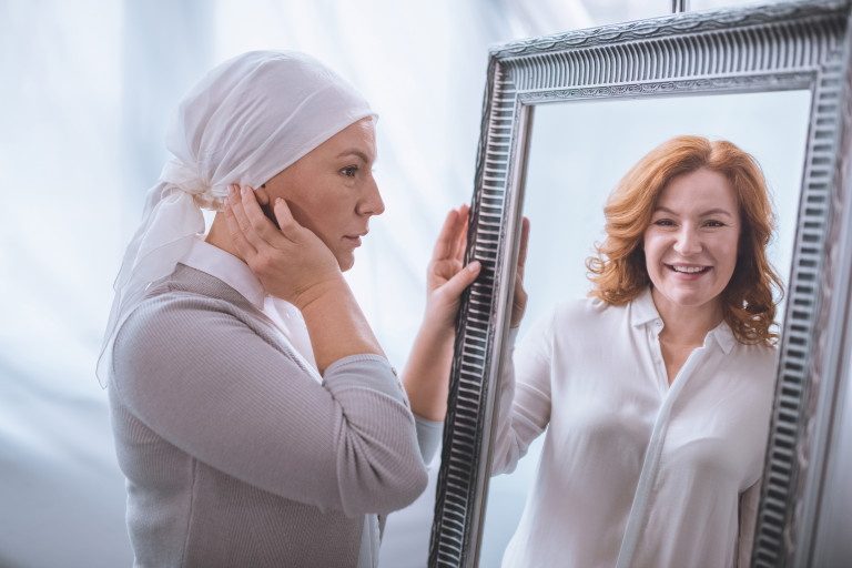 Dame malade avec un turban qui se voit comme avant dans le miroir