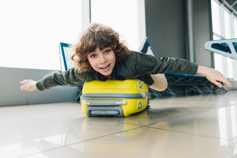 jongen op valies in luchthaven