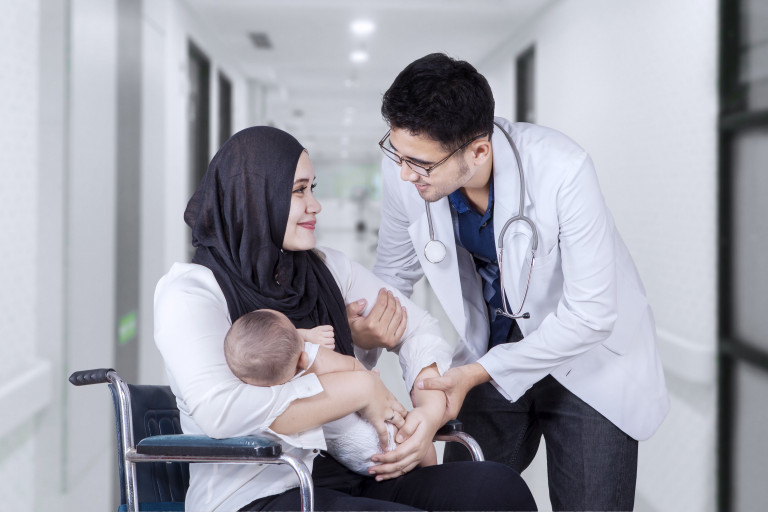 moslim vrouw met baby in ziekenhuis met dokter