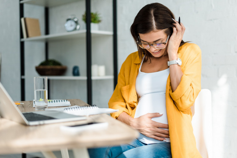 zwangere vrouw werkt op laptop