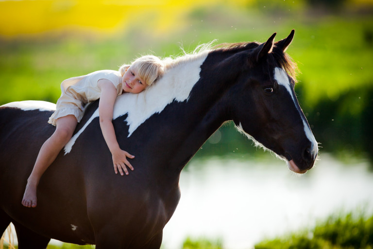 Meisje ligt op paard