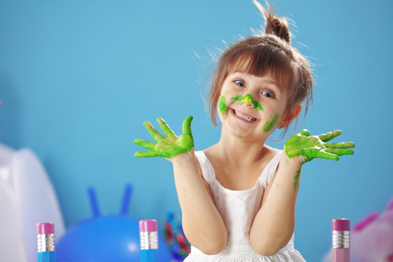 Petite fille recouverte de peinture pendant une activité