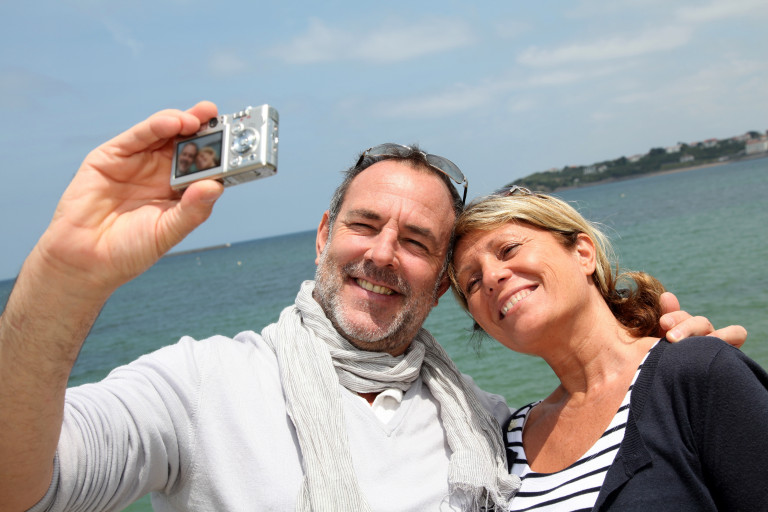 gepensioneerd koppel neem selfie aan zee