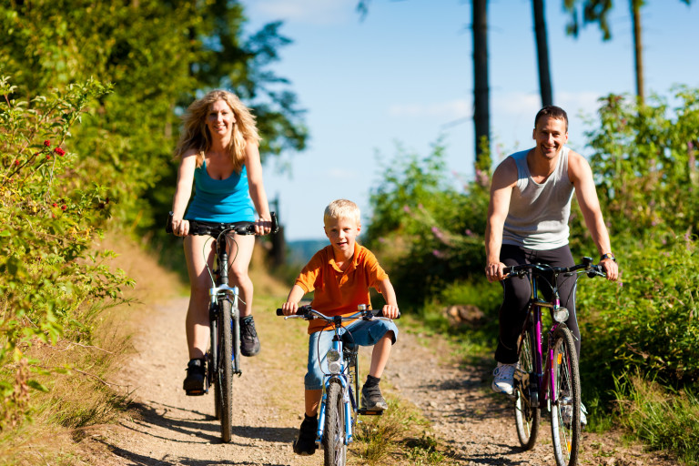 Un couple qui fait du vélo avec leur petit garçon